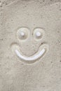 Smily face drawn on sand in white isolated background Royalty Free Stock Photo