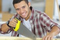 smily young workman using handsaw Royalty Free Stock Photo