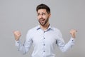 Smirked confused young unshaven business man in light shirt posing isolated on grey background studio portrait Royalty Free Stock Photo