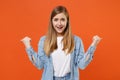 Smirked excited young woman girl in casual denim clothes posing isolated on orange background studio portrait. People Royalty Free Stock Photo