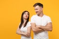 Smirked young couple two friends guy girls in white blank empty design t-shirts posing isolated on yellow orange wall Royalty Free Stock Photo
