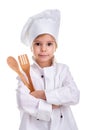 Smirking girl chef white uniform isolated on white background. Holding wooden spoon and fork in the folded hands
