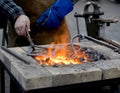 The smith heats until red a metal detail in a forge brazier Royalty Free Stock Photo