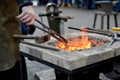 The smith keeps nippers the heated detail in a forge brazier