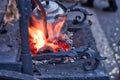 The smith is working on the horseshoe on a small forge furnace