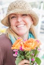Smiling Blonde Woman Wearing a Hat Holding a Fresh Cut Floral Bouquet at the Farmers Market Royalty Free Stock Photo