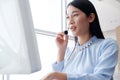 Smling asian woman is call center or secretary operator is talking with headset and a microphone for consultant to customers. Royalty Free Stock Photo