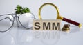 SMM concep on wooden cubes and flower ,glasses ,coins and magnifier on the white background Royalty Free Stock Photo