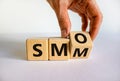 SMM vs SMO. Male hand turns a cube and changes the word `SMO - social media optimization` to `SMM - social media marketing`. Royalty Free Stock Photo