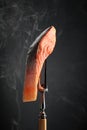 Smocked salmon piece with natural smoke on a black background
