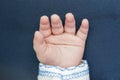 Smof newborn baby. Infant fingers and palm.  Little baby hand on blue backgroundall hand Royalty Free Stock Photo