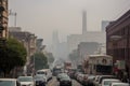 smoggy cityscape with towering smokestacks and heavy traffic