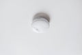 Smoke alarm, sensor or detector on white ceiling Royalty Free Stock Photo