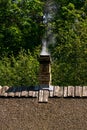 Smoke from a brick chimney on an old roof Royalty Free Stock Photo