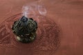 Smoke from burning incense sticks on brown decorative background Royalty Free Stock Photo