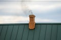 Smoke from the chimney, heating. smoke billowing. coming out of a house chimney against a blue sky background