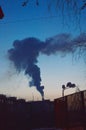 The smoke from the chimney of the heating sustem against the evening sky. Royalty Free Stock Photo