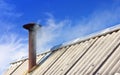 Smoke From The Chimney On The Old Roof Against The Blue Sky