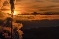 Smoke from chimny and colorful sky with sun and High Tatras mountains in Slovakia at background