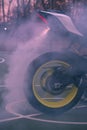 Smoking tire from motorcycle burnout with woods background