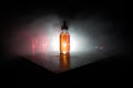 Smoke clouds and vape liquid bottles on dark background. Light effects. Useful as background or vape advertisement or vape Royalty Free Stock Photo