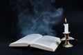 Enigmatic Aura: Smoke, Book, and Candle on Dark Background Royalty Free Stock Photo