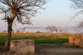 Smoke coming out of chimney of a brick kiln and farms