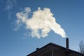 Smoke coming out of house chimney. Royalty Free Stock Photo