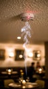 Smoke detector on ceiling with smoke below. Fire alarm system in blurred restaurant or home interior for safety and emergency Royalty Free Stock Photo