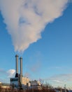 Smoke exiting two chimneys is winter