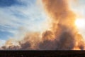 Smoke filled sky with burning farm field, wildfire