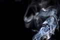 Smoke floating lighted against dark background