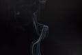 Smoke floating lighted against dark background