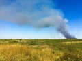 Smoke on the horizon. A fire is burning in the field. Autumn landscape Royalty Free Stock Photo