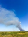 Smoke on the horizon. A fire is burning in the field. Autumn landscape Royalty Free Stock Photo