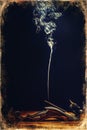 Smoke incense stick, smoke on a black background. Old photo effect.