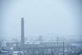 Smoke from a large pipe in an old factory pollutes the air in the winter Royalty Free Stock Photo