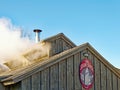 smoke from maple sugarhouse rooftop vents in early Spring boiling season