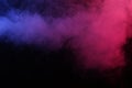 Artificial magic smoke in red-blue light on black background Royalty Free Stock Photo