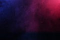 Artificial magic smoke in red-blue light on black background Royalty Free Stock Photo