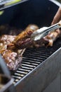 Smoke rising around a slow cooked beef brisket on the grill grates of a smoker barbecue. Grilled spare ribs macro - pork ribs Royalty Free Stock Photo