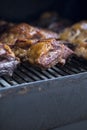 Smoke rising around a slow cooked beef brisket on the grill grates of a smoker barbecue. Grilled spare ribs macro - pork ribs Royalty Free Stock Photo