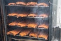 Smoke rising around a slow cooked beef brisket on a smoker barbecue grilling concept Royalty Free Stock Photo