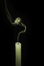 Smoke rising from an extinguished candle. Conceptual image