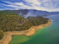 Smoke rising up from forest on shores of Tumut River.