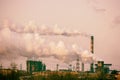 Smoke stacks in a working factory emitting steam, smog and air p