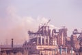 smoke stacks in a working factory emitting steam, smog pollution