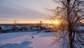 Smoke and steam comes from chimneys on the roofs of village houses against the backdrop of the morning sun in winter Royalty Free Stock Photo