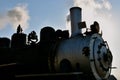 Smoke and steam are released from the engine of an old train locomotive. Royalty Free Stock Photo