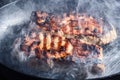 Smoke and steam rise from a pork steak on grill pan